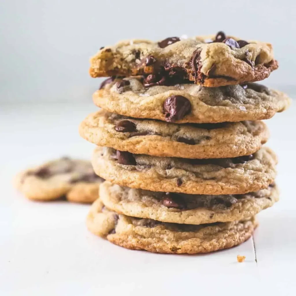 Stack of chewy chocolate chip cookies with golden crispy edges and gooey centers