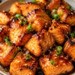 Crispy Honey Soy Salmon Bites coated in a glossy honey soy glaze with caramelized edges, sesame seeds, and sliced green onions