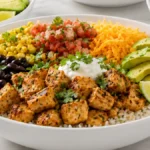 Air Fryer Chicken Burrito Bowls with juicy seasoned chicken, fluffy rice, black beans, corn, cheddar cheese, fresh salsa, avocado, cilantro, and lime for an easy Tex-Mex family dinner.